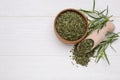 Bowl of dry tarragon, scoop and fresh leaves on white wooden table, flat lay. Space for text Royalty Free Stock Photo