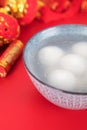A bowl of dumplings or Yuanxiao on a festive red background