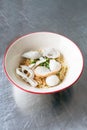 A bowl of egg noodle with variety of fish balls in Thai style on