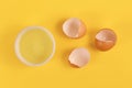 Bowl with egg white next to broken eggshells