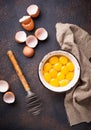 Bowl with eggs yolks and whisk