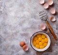 Bowl with eggs yolks and whisk