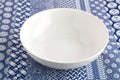 Bowl - Empty white dish on blue and white indigo table cloth background close up