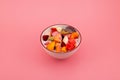 Bowl of Es Campur or Sop Buah on pink background, selective focus, copy space. Design element. Fruit salad with yogurt. Fruit iced