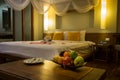 Bowl of exotic fruits and blurred background with towel swans, red rose petals on the bed, Honeymoon decoration