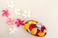 Bowl of exotic tropical sliced fruits on a wooden table with plumeria flowers Royalty Free Stock Photo