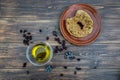 Bowl with extra virgin olive oil, olives, a fresh branch of olive tree and cretan rusk dakos close up on wooden table, Crete, Gree