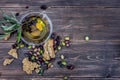 Bowl with extra virgin olive oil, olives, a fresh branch of olive tree and cretan rusk dakos close up on wooden table, Crete, Gree