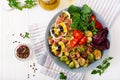 Bowl with Farfalle pasta, Brussels sprouts with bacon and fresh vegetable salad Royalty Free Stock Photo