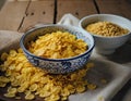 A bowl filled with corn flakes sits next to another bowl of petite flakes, ready for breakfast. The ground corn kernels offer a Royalty Free Stock Photo