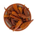 Bowl filled with dried Vietnamese chili peppers on a white background top view