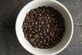 Bowl filled of fresh arabica or robusta coffee beans on a wooden table. Royalty Free Stock Photo