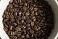 Bowl filled of fresh arabica or robusta coffee beans on a wooden table. Royalty Free Stock Photo