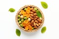 Bowl filled with variety of nuts and dried apricots placed on clean white surface. Food blogs, healthy snack advertiseme