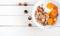 Bowl of flakes with yogurt and tangerine on white wooden table. Royalty Free Stock Photo