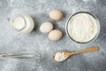 Bowl of flour, eggs and whisker on marble background