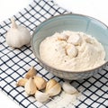 A bowl of flour and garlic on a checkered surface isolated on white background Royalty Free Stock Photo