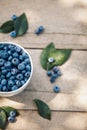 A bowl with fresh bilberry (Vaccinium myrtillus) on an old wooden bench. Fresh garden blueberries.top view Royalty Free Stock Photo