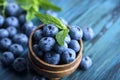 Bowl of fresh blueberries on blue rustic wooden table closeup Royalty Free Stock Photo