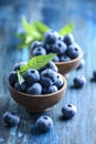 Bowl of fresh blueberries on blue rustic wooden table closeup Royalty Free Stock Photo