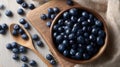The bowl of fresh blueberries surrounded by scattered berries and wooden spoon..AI generated image Royalty Free Stock Photo