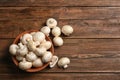 Bowl of fresh champignon mushrooms on wooden background, top view Royalty Free Stock Photo