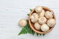 Bowl of fresh champignon mushrooms on wooden background, top view