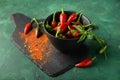 Bowl with fresh chili peppers and powder on slate plate Royalty Free Stock Photo