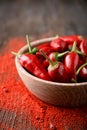 Bowl with fresh chili peppers and powder on table Royalty Free Stock Photo