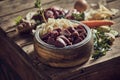 Bowl with fresh cut meat with cartilages and healthy veggies scattered on table Royalty Free Stock Photo