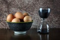 Bowl of Fresh Eggs with Sand Glass Timer on a Polished Wooden Surface with Mottled Background Royalty Free Stock Photo
