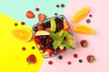 Bowl fresh fruit salad on multicolor background, top view