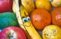 Fresh fruit with a smiley banana with a cheeky face drawn on Royalty Free Stock Photo