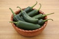 Bowl of fresh green jalapeno peppers on wooden table Royalty Free Stock Photo