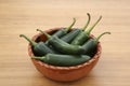 Bowl of fresh green jalapeno peppers on wooden table Royalty Free Stock Photo
