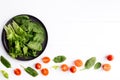 Bowl of fresh green salad leaves, lettuce, spinach and red cherry tomatoes cuts Royalty Free Stock Photo