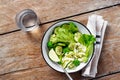 Bowl fresh green vegetable salad wooden table top view