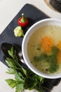 A bowl with fresh home made chiken broth with carrot and parsley