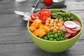 Bowl with fresh ingredients for vegetable salad on wooden table. Diet food Royalty Free Stock Photo