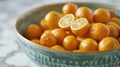 Bowl of fresh kumquats and halved lemon on a marble countertop Royalty Free Stock Photo