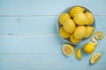 Bowl with fresh lemons on blue wooden background. Top view Royalty Free Stock Photo
