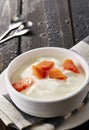 Bowl of fresh mixed berries and yogurt with farm fresh Papaya on a wooden table Royalty Free Stock Photo