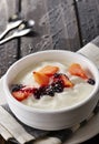 Bowl of fresh mixed berries and yogurt with farm fresh Papaya on a wooden table Royalty Free Stock Photo
