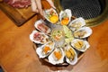 A bowl of Fresh Oyster topped with sea urchin roe uni, salmon roe ikura, wagyu beef, marinated egg yolk and spicy seafood Royalty Free Stock Photo