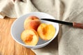 Bowl with fresh peaches and knife on wooden table Royalty Free Stock Photo