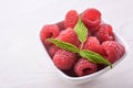 Bowl of fresh raspberries with green leaves on wooden background. Top view Royalty Free Stock Photo