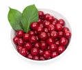 Bowl of fresh red cherries and green leaves isolated on a white background, top view Royalty Free Stock Photo