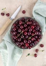 Bowl of fresh red cherries and knife on beige background. Top view Royalty Free Stock Photo