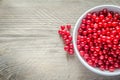 Bowl with fresh redcurrant on the wooden table Royalty Free Stock Photo