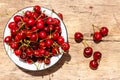 Bowl with fresh ripe cherries on rustic wooden table. Top view Royalty Free Stock Photo